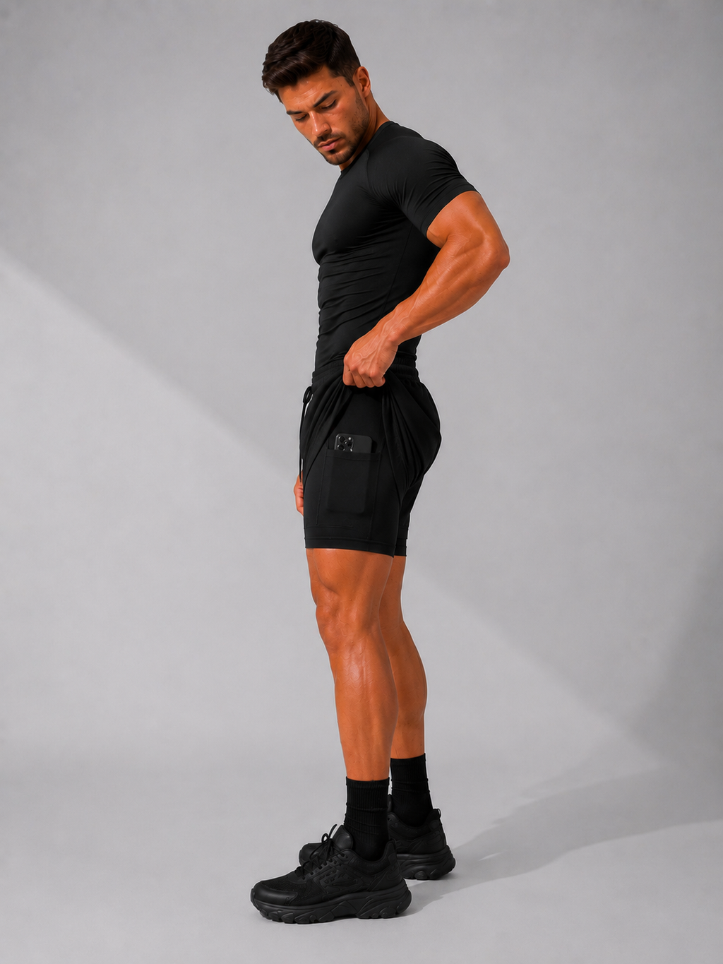 Mann trägt die 2-in-1 Performance Short in Shadow Black, Seitenansicht