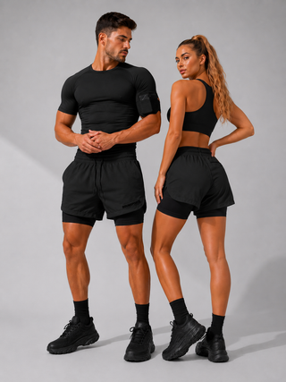 Mann und Frau tragen die 2-in-1 Performance Short in Shadow Black